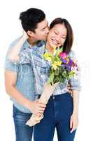 Man kissing woman and giving her flowers