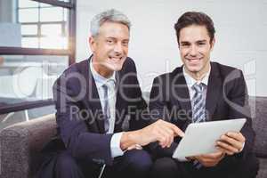 Portrait of smiling businessmen with digital tablet