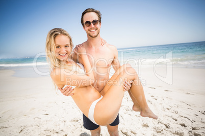 Man holding woman in his arms on the beach