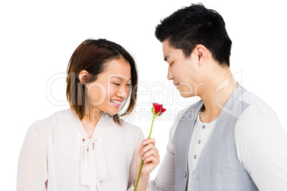 Young woman giving a rose to man