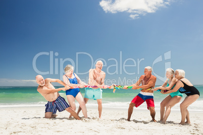 Senior friends playing tug of war