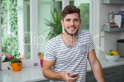 Portrait of smiling man holding phone