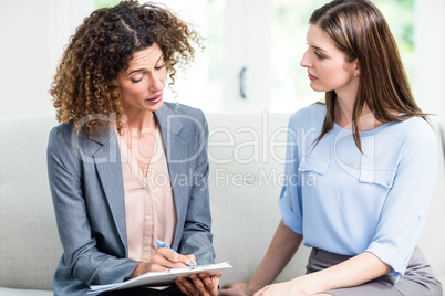 Psychologist advising young woman at home