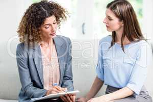 Psychologist advising young woman at home