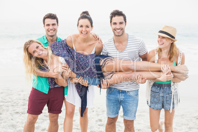 Group of friends lifting a woman