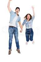 Excited young couple holding hands and jumping