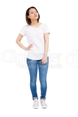 Thoughtful young woman standing with hands on hip