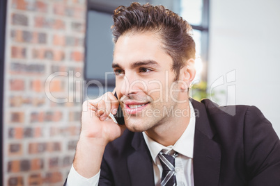 Businessman talking on mobile phone in office