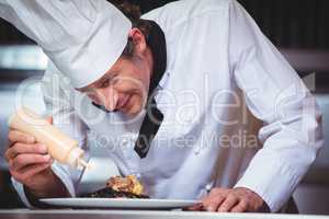 Chef putting sauce on a dish of spaghetti