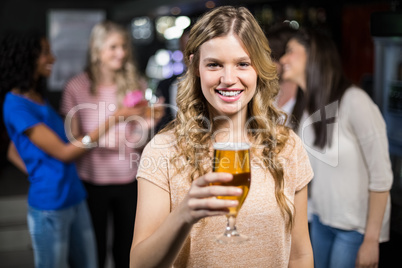 Smiling girl having a beer with her friends