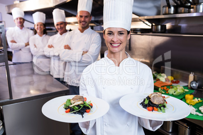 Team of chefs with one presenting dishes