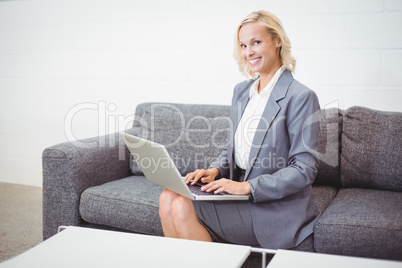 Portrait of smiling bussinesswoman working on laptop