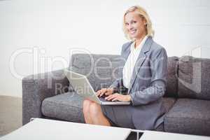 Portrait of smiling bussinesswoman working on laptop