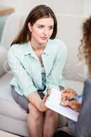 Beautiful young woman discussing with psychologist