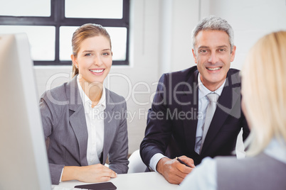 Smart business people sitting at desk in office