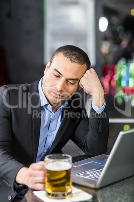 Worried businessman drinking a beer