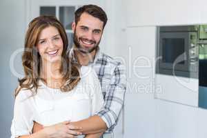 Happy young couple embracing at home