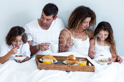 Family having breakfast in bed