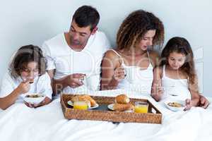 Family having breakfast in bed