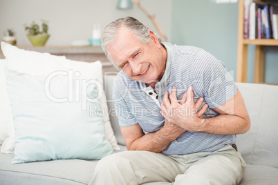 Senior man laughing  while sitting on sofa