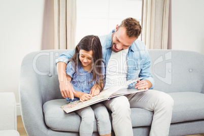 Father and daughter reading book