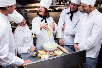 Head chef teaching his team to prepare a dough
