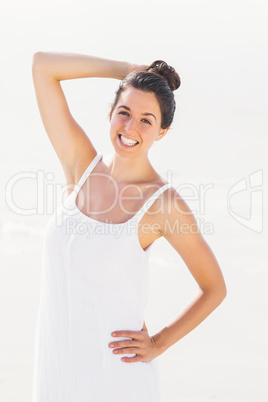 Happy woman in white outfit standing on the beach