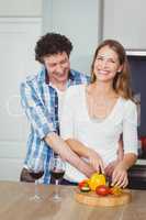 Portrait of smiling wife with husband in kitchen