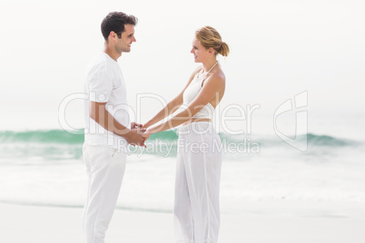 Romantic couple holding hands on the beach