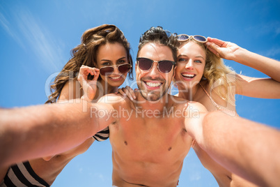 Happy friends taking selfie on the beach