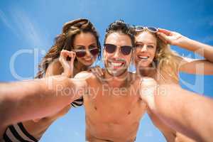 Happy friends taking selfie on the beach