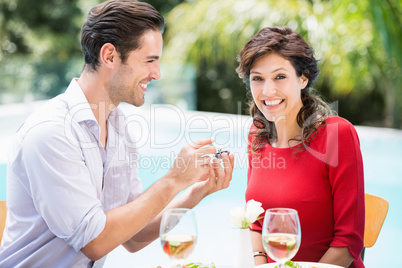 Portrait of smiling woman while receiving giving engagement ring