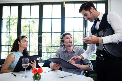 Waiter taking an order for a couple