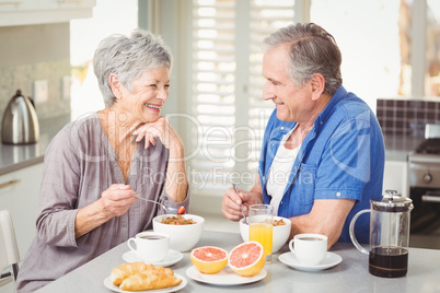 Happy senior couple discussing while having breakfast