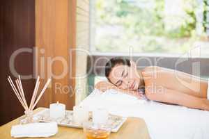 Young woman relaxing on massage table at health spa