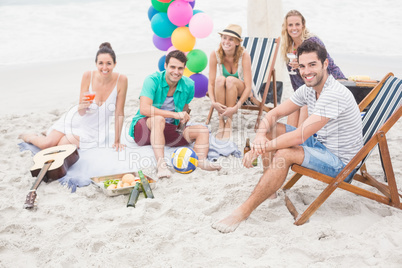 Group of friends with drinks having fun together on the beach