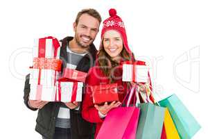 Happy young couple holding gifts and shopping bags