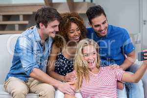 Cheerful young friends taking selfie at home