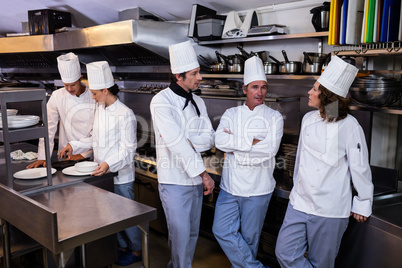Team of chefs standing together in commercial kitchen