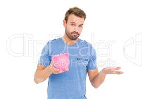 Young man holding a piggy bank