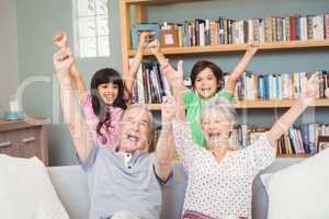 Grandparents with grandchildren gesturing success sign