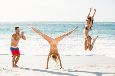 Beautiful excited friends jumping on the beach