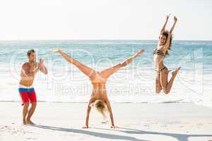 Beautiful excited friends jumping on the beach
