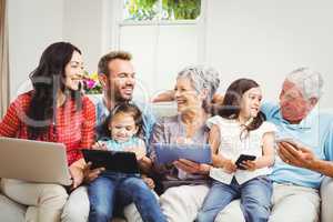 Family smiling while holding technologies