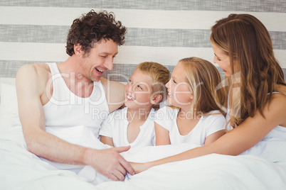 Smiling family resting on bed