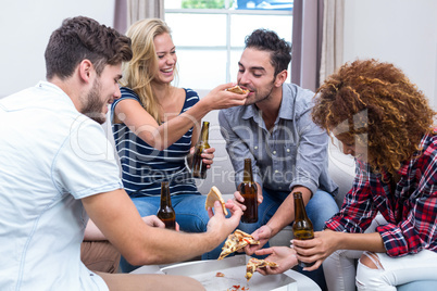 Cheerful multi-ethnic friends enjoying beer and pizza