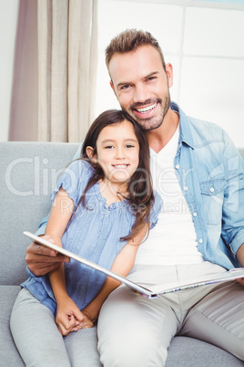 Portrait of smiling father with daughter at home