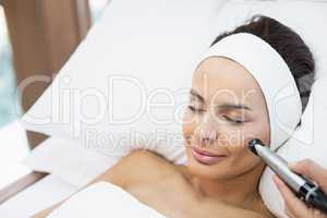 Close-up of topless woman receiving facial massage