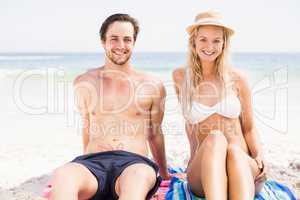 Portrait of young couple sitting on the beach