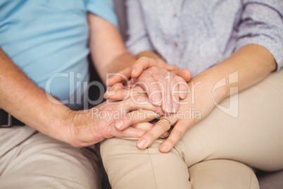 Midsection of couple holding hands